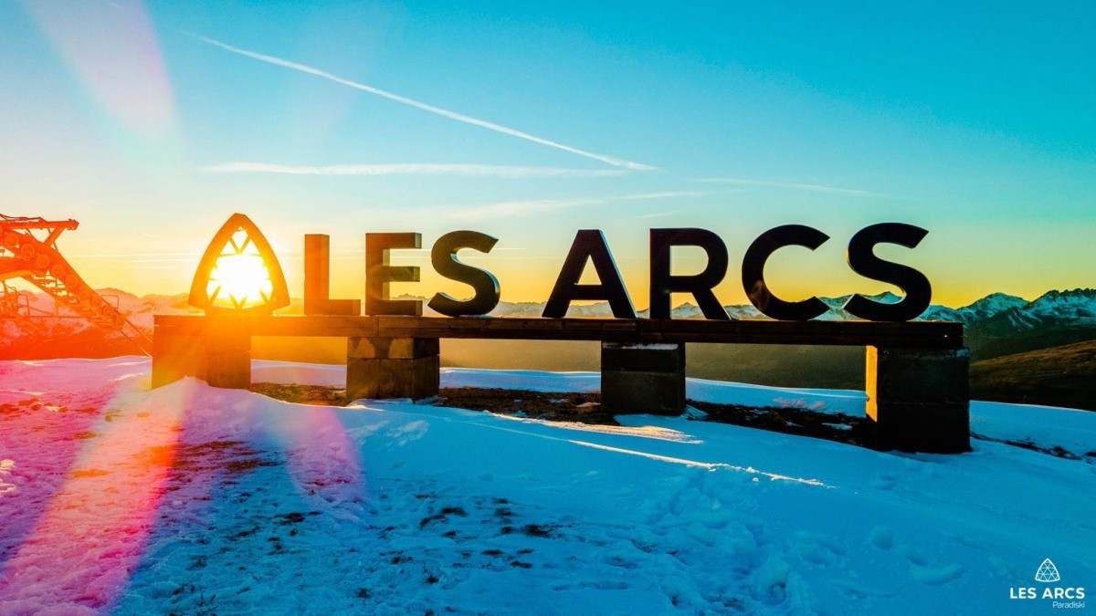 Lettres Les Arcs devant les montagnes enneigées au soleil