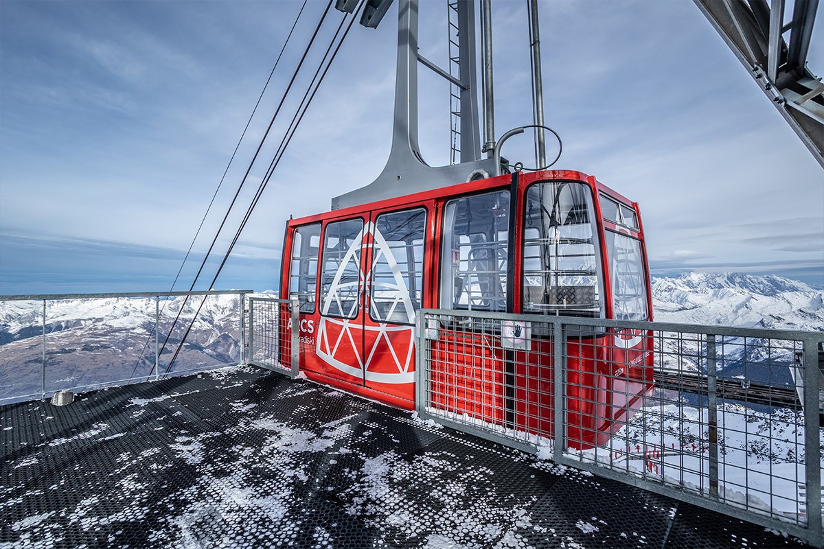 Cabine rouge de téléphérique dans un paysage enneigé